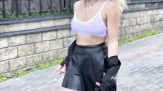 Shows breasts in the city, in a crowded place. public